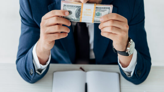 Cropped,View,Of,Man,Smelling,Dollar,Banknotes,Near,Notebook,And