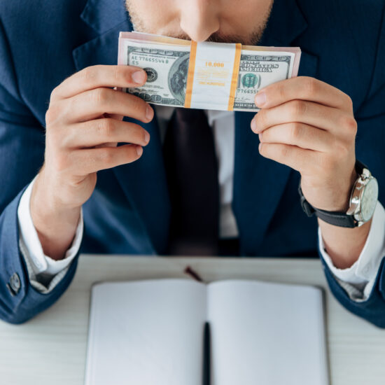 Cropped,View,Of,Man,Smelling,Dollar,Banknotes,Near,Notebook,And