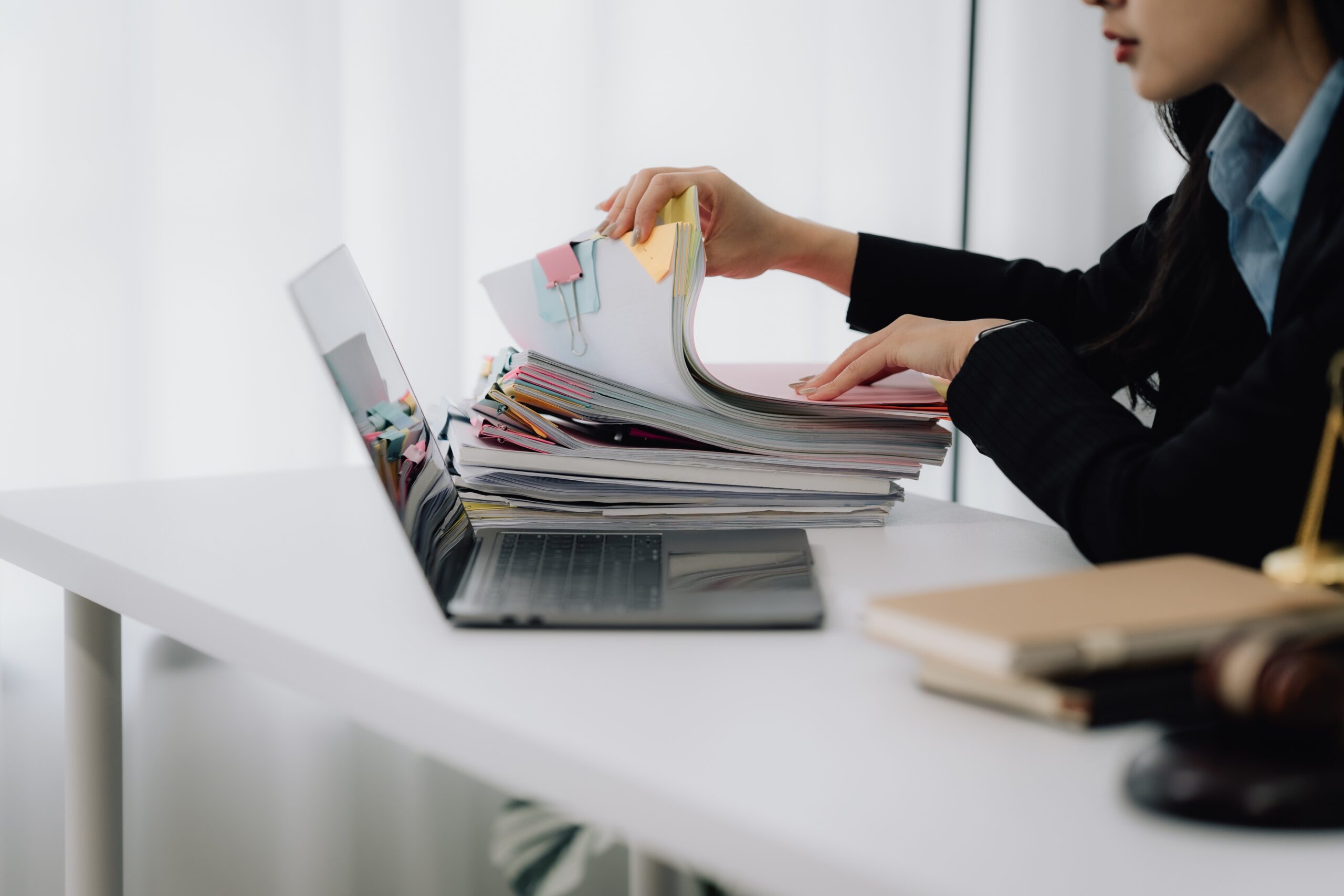 Woman,Reviewing,Legal,Documents,At,Desk